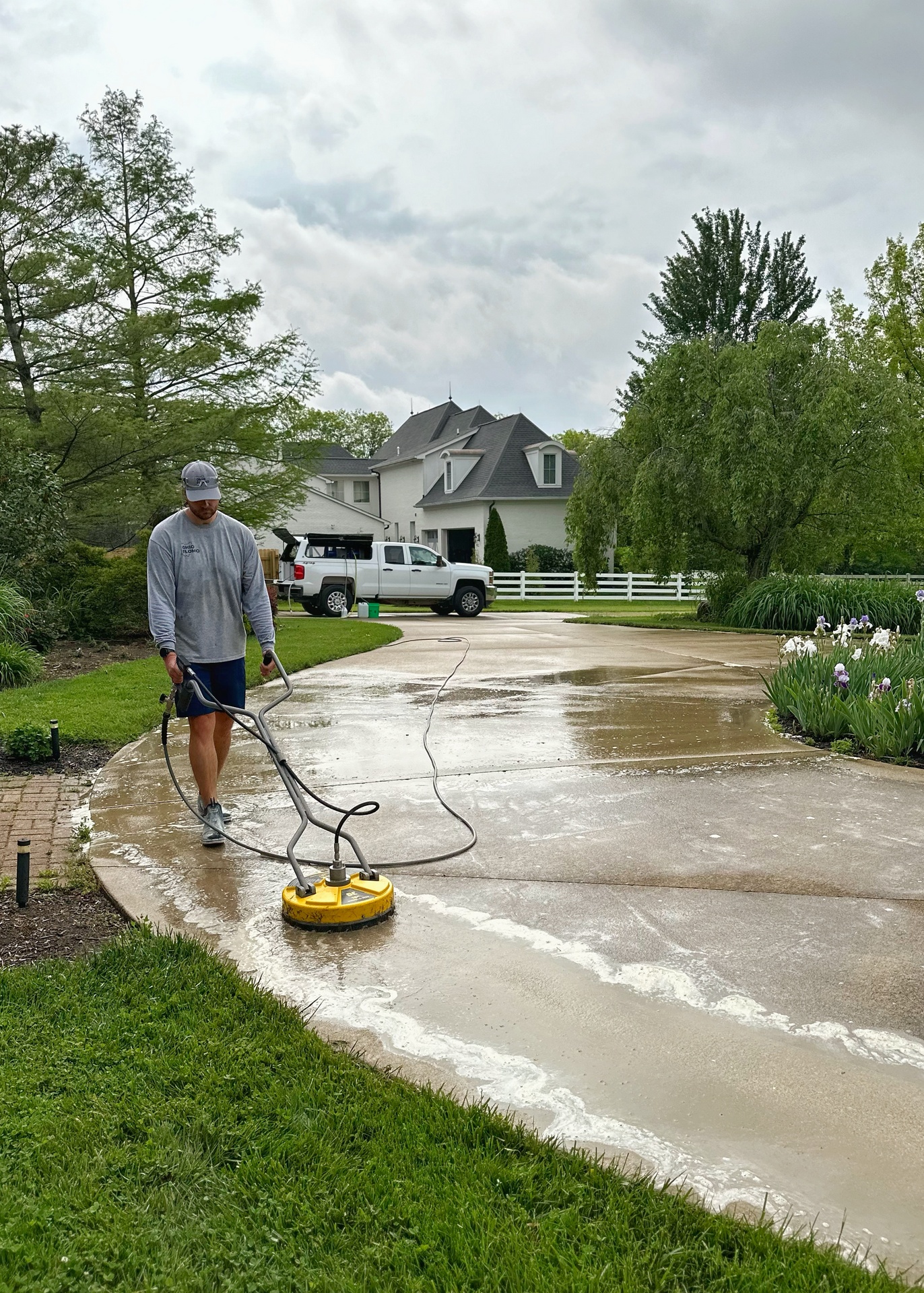 Owner Anton using a surface cleaner to expertly clean a driveway with Ohio Flomo pressure washing services